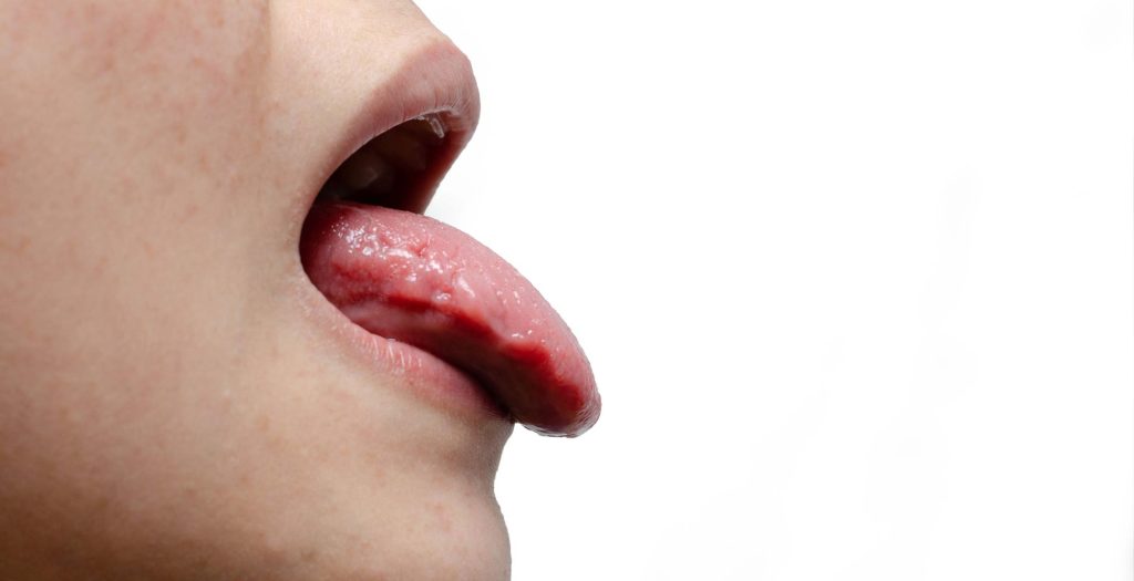persona de perfil sacando la lengua