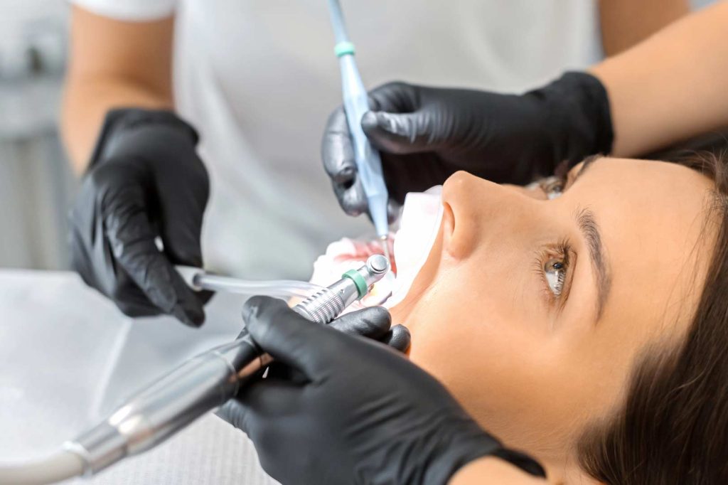 Paciente mujer sometiéndose a una limpieza dental profesional