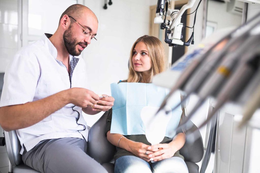 Dentista explicando a paciente qué es el pH bucal
